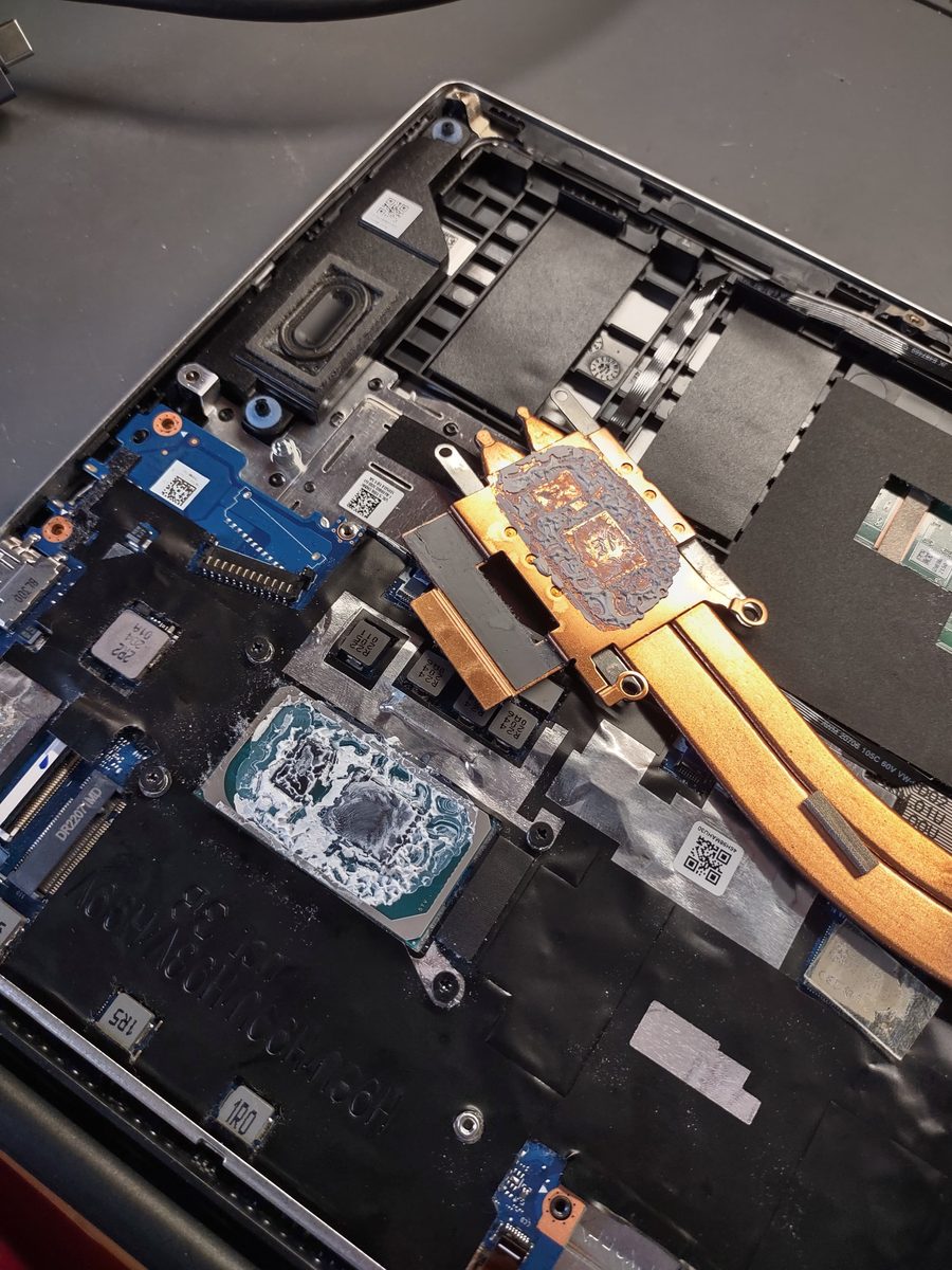 Pulizia dissipatore e sostituzione pasta termica su notebook a Monza: dissipatore smontato con pasta secca su CPU e GPU